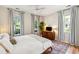 Bright main bedroom with hardwood floors, ceiling fan, dresser, and light gray curtains at 2900 Split Hickory Ct, Johns Island, SC 29455