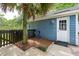 Charming side yard with blue siding, mature landscaping, palm tree, and decorative bottle art at 2900 Split Hickory Ct, Johns Island, SC 29455