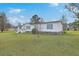 Exterior view of white home with blue shutters, stone accents, and a spacious front lawn at 307 Glen St, Summerville, SC 29483