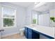 Charming bathroom with a large mirror, blue vanity, and a window offering natural light and neighborhood views at 3203 Moonlight Dr, Charleston, SC 29414