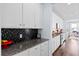 Galley kitchen featuring white cabinets and granite countertops and wood floors at 3203 Moonlight Dr, Charleston, SC 29414