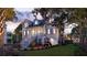 Stunning two-story home with inviting front porch, well-lit facade, and lush landscaping at dusk at 3307 Waterway Blvd, Isle of Palms, SC 29451
