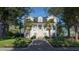 Charming two-story home with landscaped yard, grand front entrance, driveway, and mature palm and hardwood trees at 3307 Waterway Blvd, Isle of Palms, SC 29451