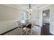 Formal dining room featuring wainscoting, dark wood floors, and elegant lighting fixture at 332 Clayton Dr, Charleston, SC 29414