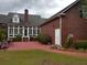 Brick home exterior showcasing a patio area, screened-in porch, and well-kept lawn at 351 Duncan Chapel Rd, Harleyville, SC 29448