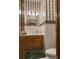 Powder room with toilet, vanity, and decorative striped wallpaper at 351 Duncan Chapel Rd, Harleyville, SC 29448