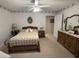 Cozy bedroom with neutral carpet, a decorative bedspread, and a vintage-style mirror on the dresser at 351 Duncan Chapel Rd, Harleyville, SC 29448