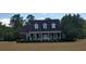 Charming brick home featuring a covered porch, manicured lawn, and classic architectural details at 351 Duncan Chapel Rd, Harleyville, SC 29448