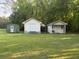 View of three small outbuildings on a well-maintained, level, grassy lot shaded by tall trees at 351 Duncan Chapel Rd, Harleyville, SC 29448