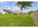 Grassy backyard with privacy fence, mature tree, firepit, and trampoline provides ample space for outdoor activities at 405 Watershed Dr Dr, Goose Creek, SC 29445