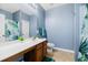 Standard bathroom with blue walls, a light wood vanity, a white toilet, and a tropical shower curtain at 405 Watershed Dr Dr, Goose Creek, SC 29445
