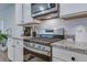 Close-up view of stainless steel range with granite countertops and white cabinets in a modern kitchen at 444 Cedarview Rd, Summerville, SC 29486