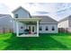 Backyard with a covered patio, lush green lawn, perfect for outdoor entertaining and relaxation at 447 Navona Dr, Summerville, SC 29486