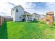 Large backyard with a covered patio, lush green lawn, and a play set, great for and outdoor activities at 447 Navona Dr, Summerville, SC 29486