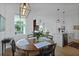 Bright dining area featuring a round table, modern light fixture, and open-concept design leading to the kitchen at 48 Aiken St, Charleston, SC 29403