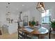 Bright dining area featuring a round table, modern light fixture, and open-concept design leading to the kitchen at 48 Aiken St, Charleston, SC 29403