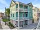 Charming three-story home with lovely pale-green siding and double-decker porches and white railings at 48 Aiken St, Charleston, SC 29403