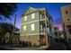 Nighttime view of home exterior showcasing well-lit balconies, a two-car garage, and landscape at 48 Aiken St, Charleston, SC 29403