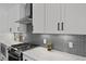 Up-close view of kitchen with modern appliances, gray backsplash, and white countertops at 48 Aiken St, Charleston, SC 29403