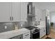 Close-up showcasing kitchen with modern appliances, white cabinets, and stainless steel range hood at 48 Aiken St, Charleston, SC 29403