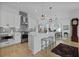 Modern kitchen with white cabinets, island, stainless steel appliances, and an adjacent dining area at 48 Aiken St, Charleston, SC 29403