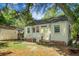 Back exterior of home and backyard, featuring brick foundation and lush greenery at 4810 Parkside Dr, North Charleston, SC 29405