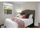 Well-lit bedroom with a comfortable-looking bed with light pink blanket, a large window and hardwood floors at 4810 Parkside Dr, North Charleston, SC 29405