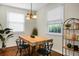 Bright dining room features a wooden table with black chairs, light fixture, and natural light at 4810 Parkside Dr, North Charleston, SC 29405