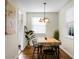 Cozy dining room featuring hardwood floors, a modern light fixture, a rustic wood table, and natural light from the windows at 4810 Parkside Dr, North Charleston, SC 29405