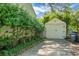 View of a single car garage at the end of a driveway, bordered by greenery, with a blue sky in the background at 4810 Parkside Dr, North Charleston, SC 29405