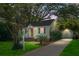 Charming home exterior featuring a well-maintained yard, lush landscaping, a paved driveway, and a detached garage on a sunny day at 4810 Parkside Dr, North Charleston, SC 29405