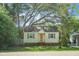 Charming single-story home featuring a well-manicured lawn, mature trees, and a classic architectural design with shutters on the windows at 4810 Parkside Dr, North Charleston, SC 29405