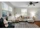 Bright living room with large windows, a plush sectional sofa, stylish rug, and modern decor creating a welcoming space at 4810 Parkside Dr, North Charleston, SC 29405