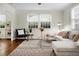 Bright living room with large windows, a stylish rug, and comfortable seating, creating a cozy and inviting atmosphere at 4810 Parkside Dr, North Charleston, SC 29405