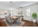 Charming dining room with a wooden table, upholstered chairs, decorative rug, and sunlit windows at 4818 Buttercup Way, Summerville, SC 29485