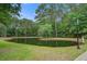 Beautiful community pond surrounded by lush landscaping and mature trees at 4818 Buttercup Way, Summerville, SC 29485