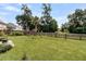 Large backyard with green grass, swing, fenced perimeter, landscaping, and mature trees at 5257 Mulholland Dr, Summerville, SC 29485