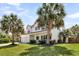 Inviting two-story home with a well-maintained lawn, mature palm trees, and a classic design at 5257 Mulholland Dr, Summerville, SC 29485