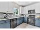 Stylish kitchen featuring stainless steel appliances, granite countertops, and a combination of white and blue cabinets at 5257 Mulholland Dr, Summerville, SC 29485