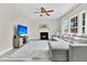 Bright living room showcasing fireplace, windows, ceiling fan and large sectional couch at 5257 Mulholland Dr, Summerville, SC 29485