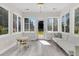 Bright sunroom with large windows, modern flooring, and a cozy seating area that leads to the backyard at 5257 Mulholland Dr, Summerville, SC 29485