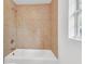 Tiled bathtub with a shower head and fixtures, complemented by a bright, natural light source from the adjacent window at 5375 Highway 174, Adams Run, SC 29426