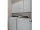 Efficient laundry area with front-load washer, dryer, and overhead white cabinets at 546 Sea Foam St, Summerville, SC 29486