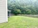 Large, grassy backyard with a wooden fence and mature trees, ideal for recreation and privacy at 610 Knowledge Dr, Ladson, SC 29456