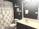 Bathroom features a dark vanity with modern sink, decorative patterned shower curtain, and stylish decor details at 610 Knowledge Dr, Ladson, SC 29456