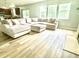Living room featuring a large sectional couch, plush ottoman, and light wood-look floors at 610 Knowledge Dr, Ladson, SC 29456