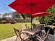 Backyard patio setup for outdoor living with table, chairs and umbrellas on the patio under blue skies at 7 Lavington Rd, Charleston, SC 29407