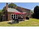 Brick home featuring an outdoor patio with a large, manicured lawn and stylish patio furniture for entertaining at 7 Lavington Rd, Charleston, SC 29407
