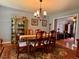 Formal dining room with elegant chandelier, wood table with seating for six, and hardwood floors at 7 Lavington Rd, Charleston, SC 29407