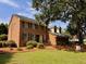 A lush green lawn complements this two-story brick home with dormer windows and neat landscaping at 7 Lavington Rd, Charleston, SC 29407